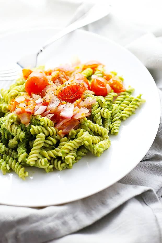 this Healthy Pesto Pasta is Vegan and Gluten Free! healthy and super simple to make! topped with sauteed tomatoes and onions!