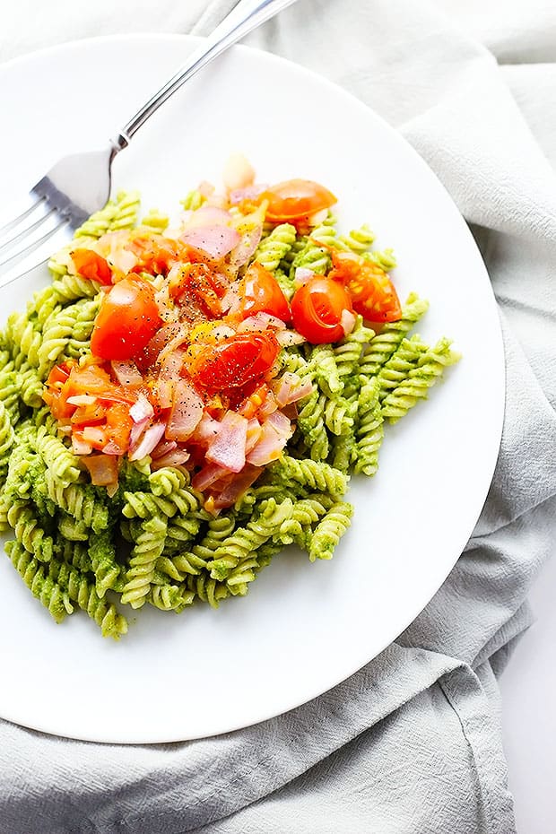 this Healthy Pesto Pasta is Vegan and Gluten Free! healthy and super simple to make! topped with sauteed tomatoes and onions!