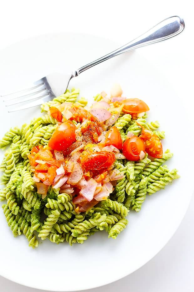 this Healthy Pesto Pasta is Vegan and Gluten Free! healthy and super simple to make! topped with sauteed tomatoes and onions!