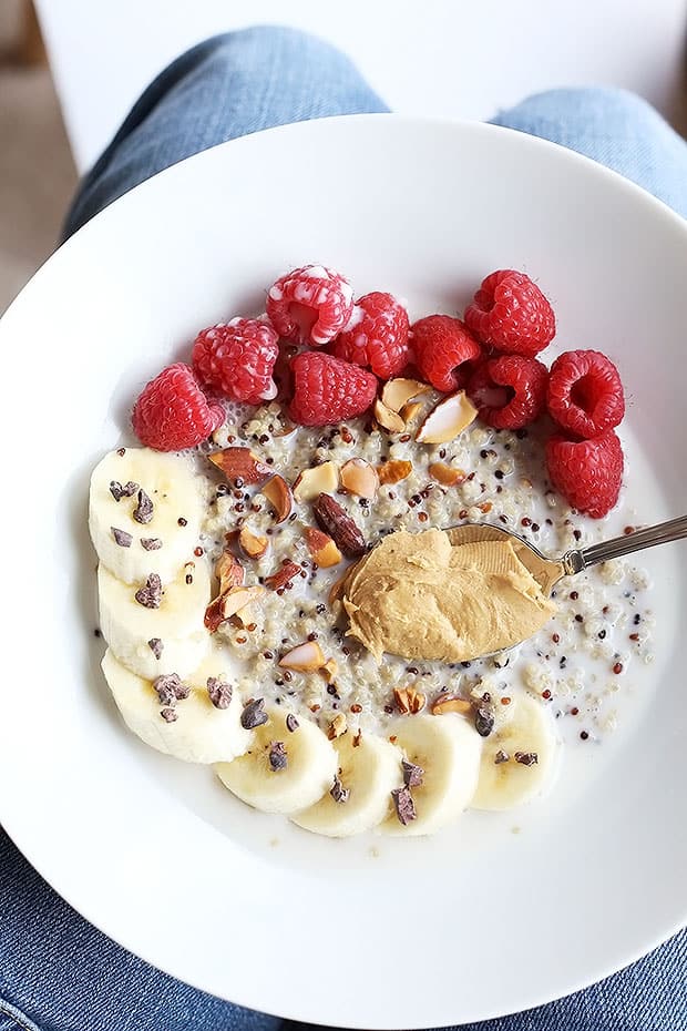 This 7 ingredient superfood quinoa breakfast bowl is SO quick and easy to make and PERFECT for a grab and go breakfast! Topped with raspberries, bananas, nuts and cacao nibs! / TwoRaspberries.com