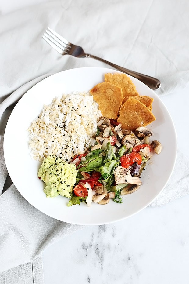This Healthy Fajita Bowl is SUPER easy to make and perfect for lunch or dinner! A blend of natural flavors come together beautifully! Rice, lime avocado, soft tortilla chips and sauteed mushrooms and tomatoes! / TwoRaspberries.com