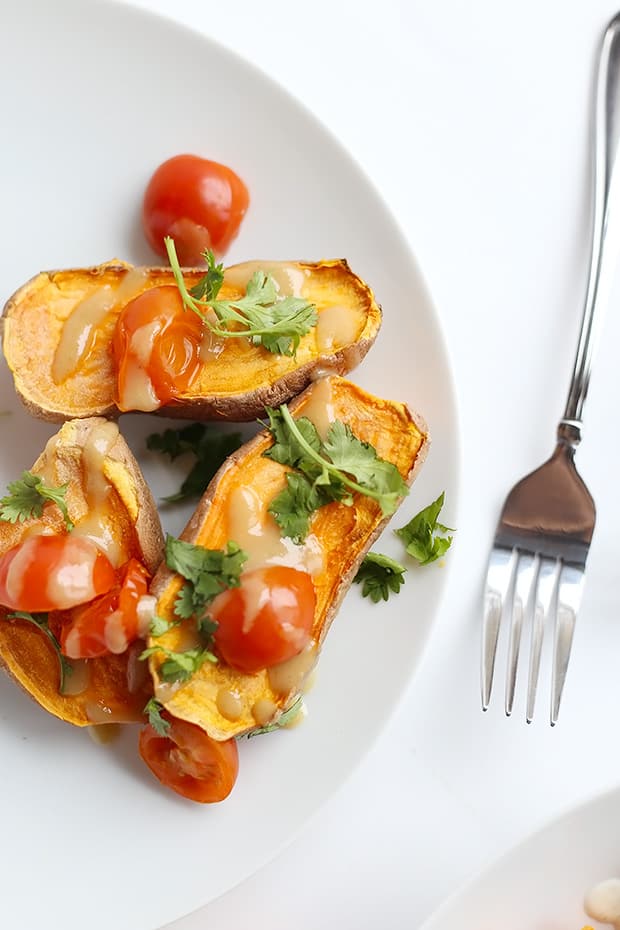 These Healthy Baked Sweet Potatoes with Lime Tahini Sauce are the perfect comforting dinner! Two sauce options included! Vegan and Gluten Free. / TwoRaspberries.com