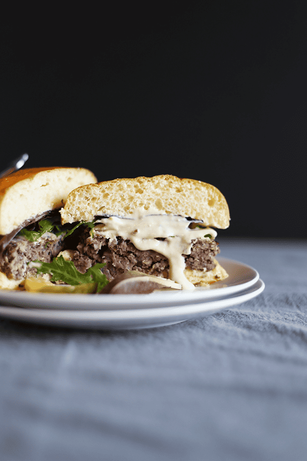 These 5 Ingredient Garlic Onion Black Bean Burgers are SO easy to make, paired with a tahini lime sauce, healthy, VEGAN and GF! | TwoRaspberries.com