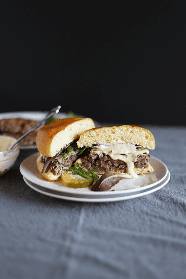 These 5 Ingredient Garlic Onion Black Bean Burgers are SO easy to make, paired with a tahini lime sauce, healthy, VEGAN and GF! | TwoRaspberries.com