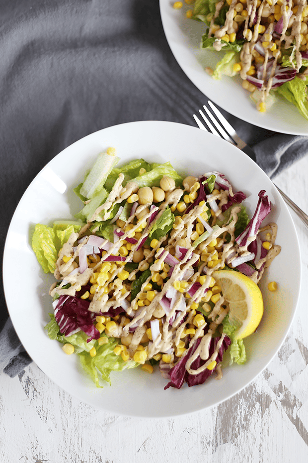 This Easy Clean Chickpea Corn Salad is healthy, quick and easy to make, packed with protein and healthy fats, paired with a chili tahini dressing! Vegan, GF | TwoRaspberries.com