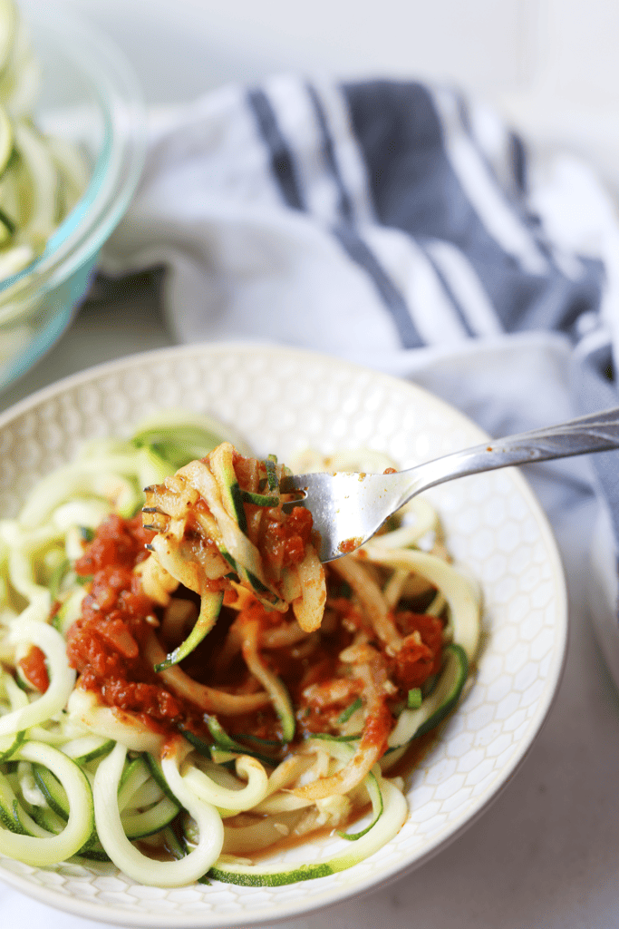big bit of zoodles with marinara sauce on top