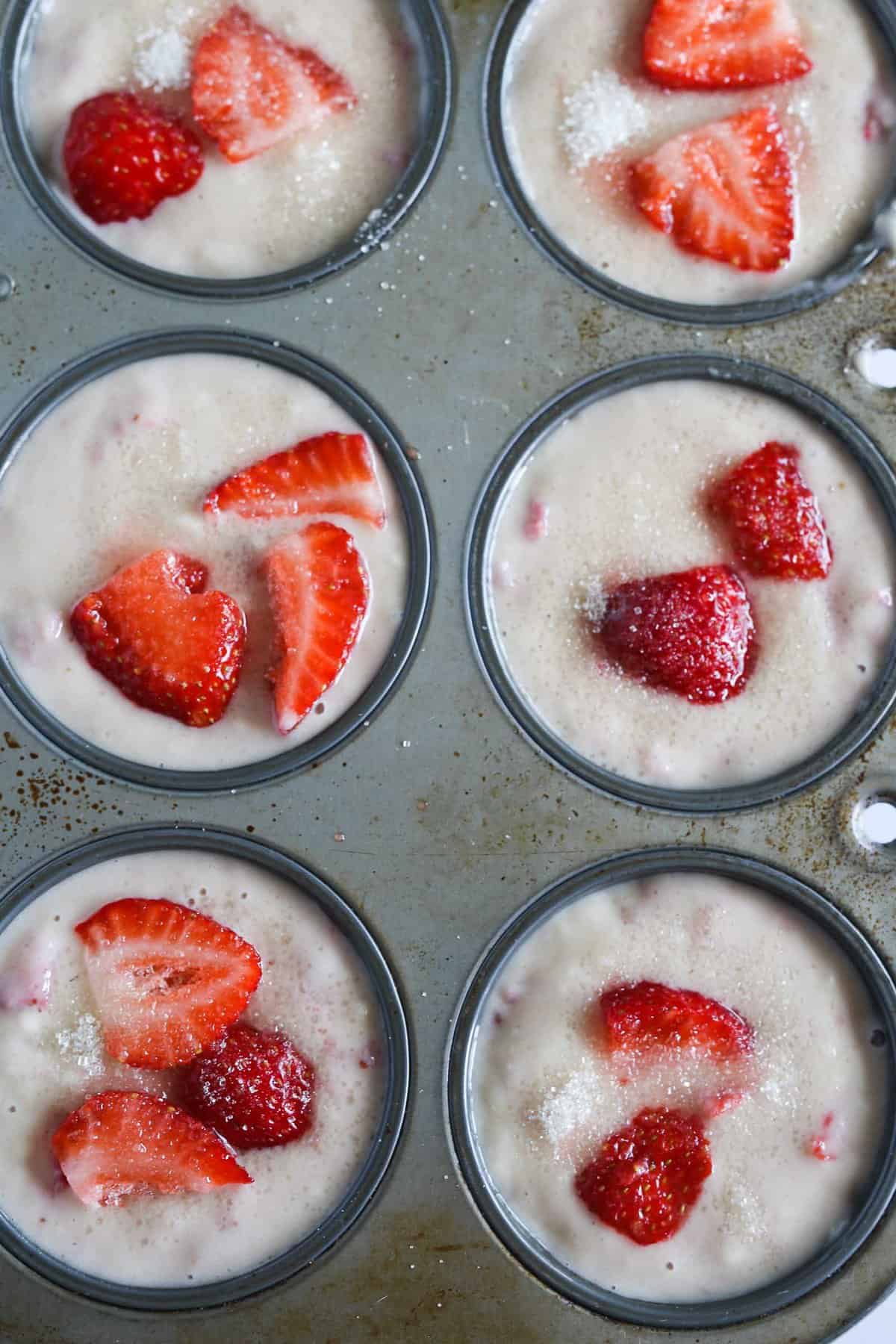Unbaked vegan strawberry muffin batter in muffin tin.