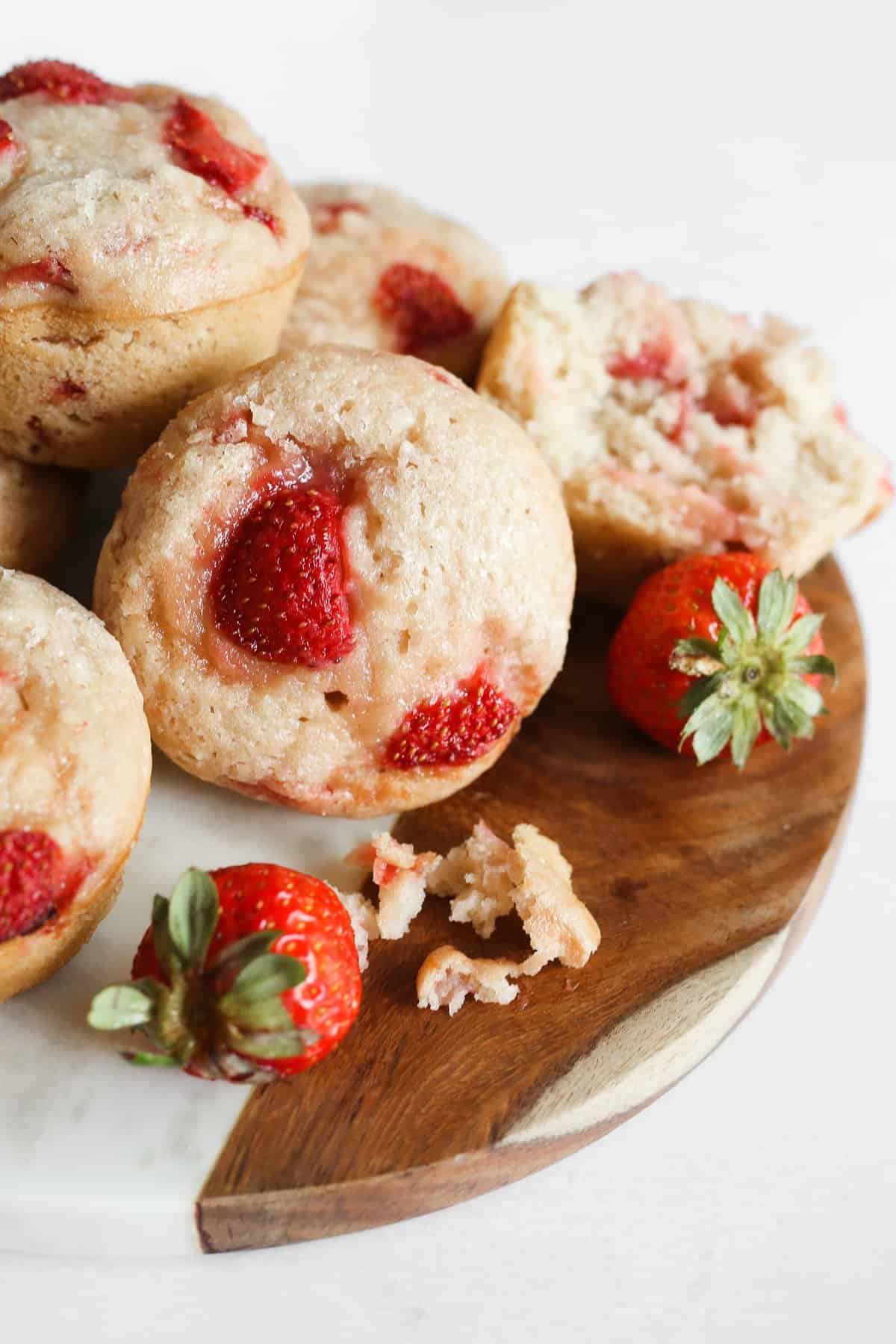 Strawberry vegan muffins on a marble and wood plate.