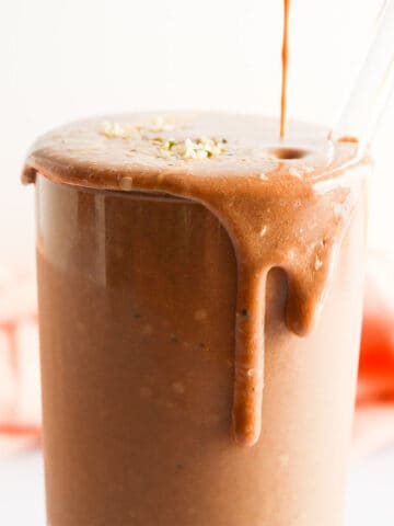 Pouring a chocolate smoothie into a glass.