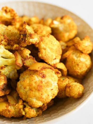 Roasted curry cauliflower in a bowl on the table.