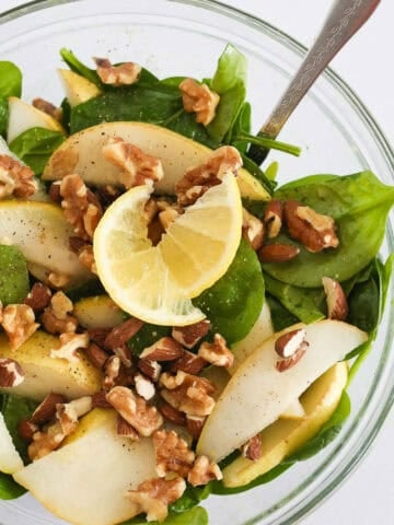 1200 x 1200 image of the Pear Almond Salad in a glass bowl with a fork.