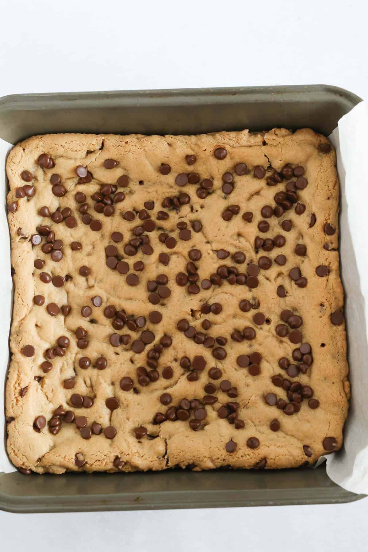 Freshly bakes Chocolate Chip Cookie Bars in a baking pan.