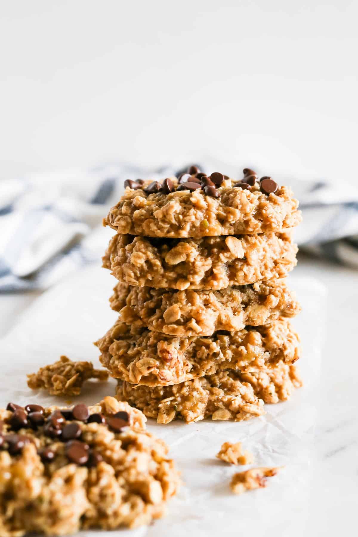 Banana Peanut Butter Oatmeal Cookies stacked on top each other sitting on a marble table.