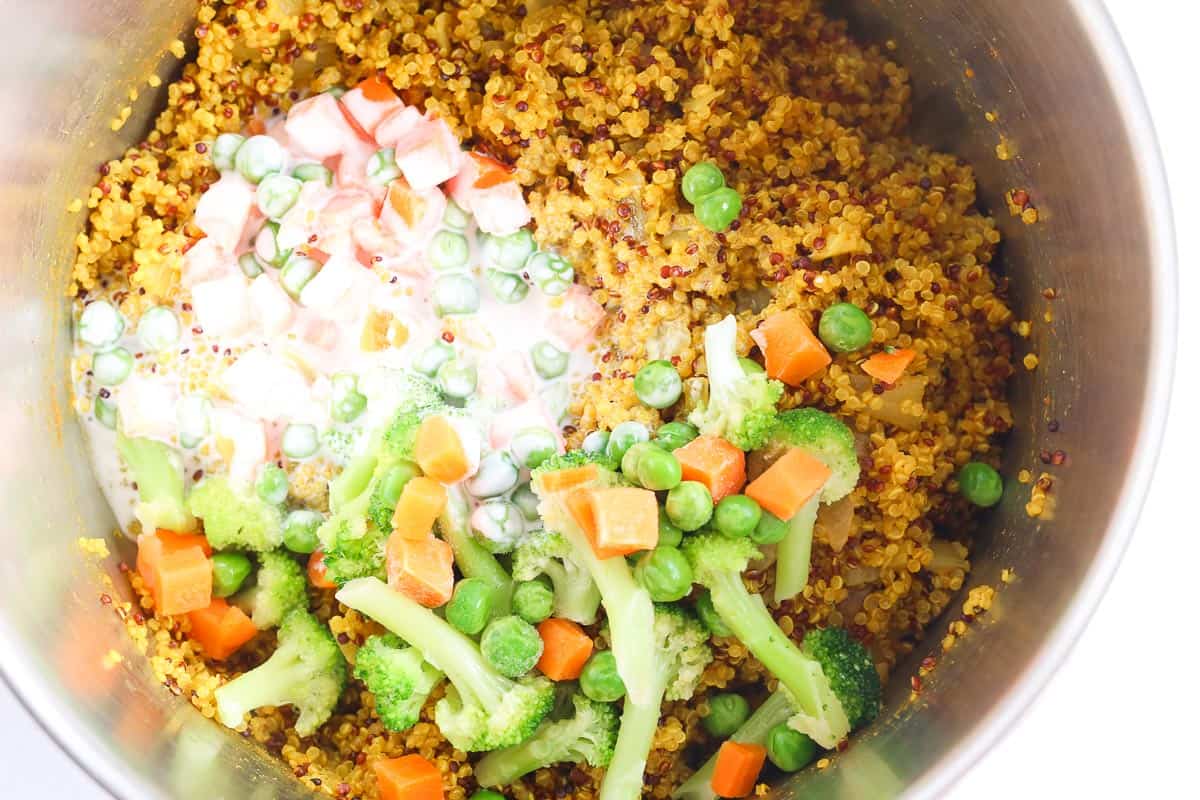 Curry Quinoa with vegetables and coconut milk added to pot.