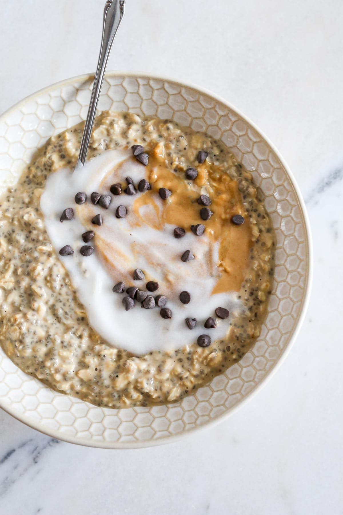 Peanut Butter Overnight Oats with yogurt, peanut butter and chocolate chips on top.