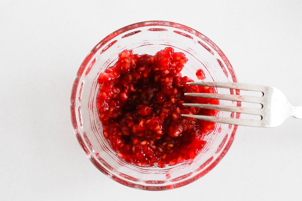 Small glass bowl with mashed raspberries.