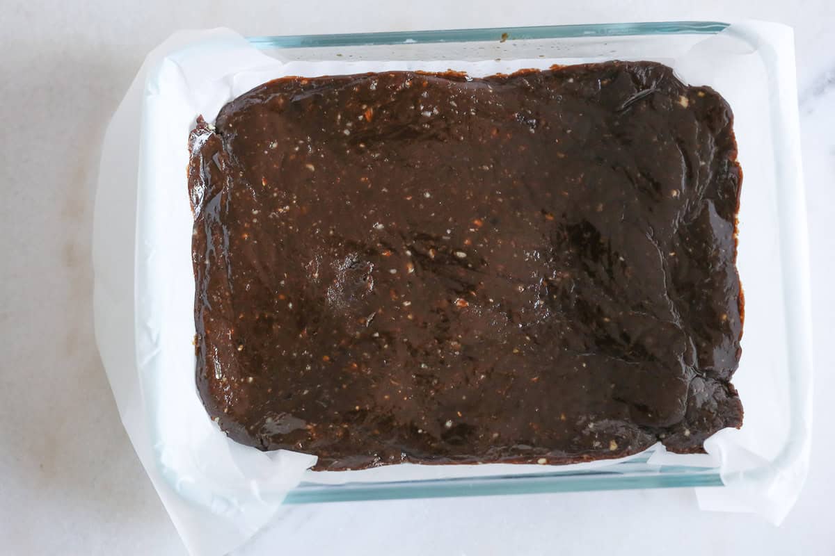 3 Ingredient No Bake Vegan Brownies pressed down flat in container ready to freeze.