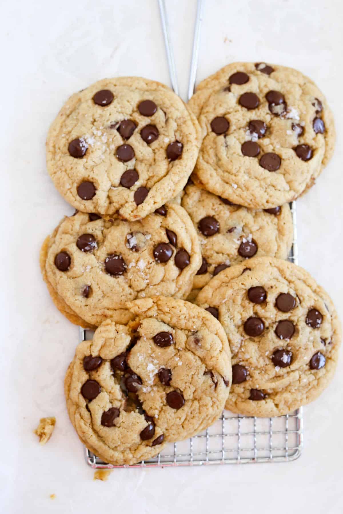 Crispy Chocolate Chip Cookies stacked on top each other on wire rack.