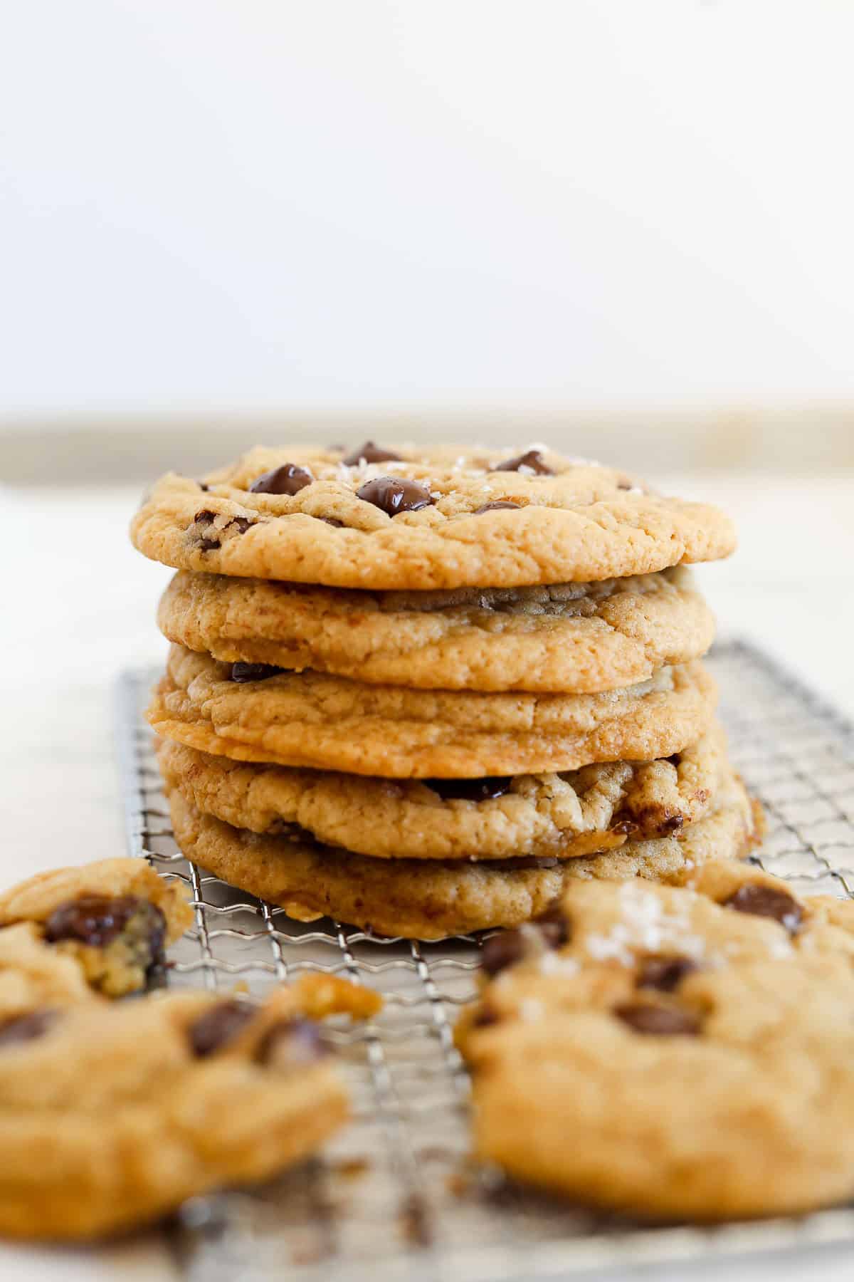 Crispy Chocolate Chip Cookies stacked on top each other side view.