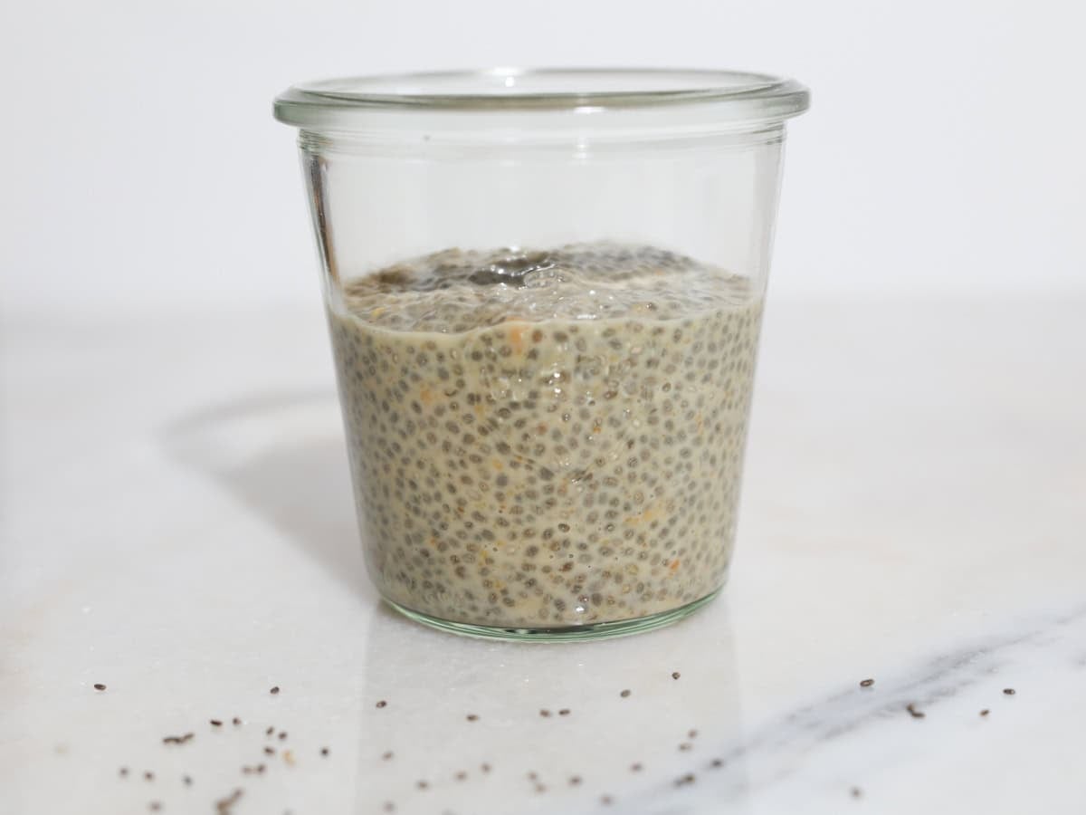 Chia seed pudding with peanut butter added to a glass jar to be layered for serving.
