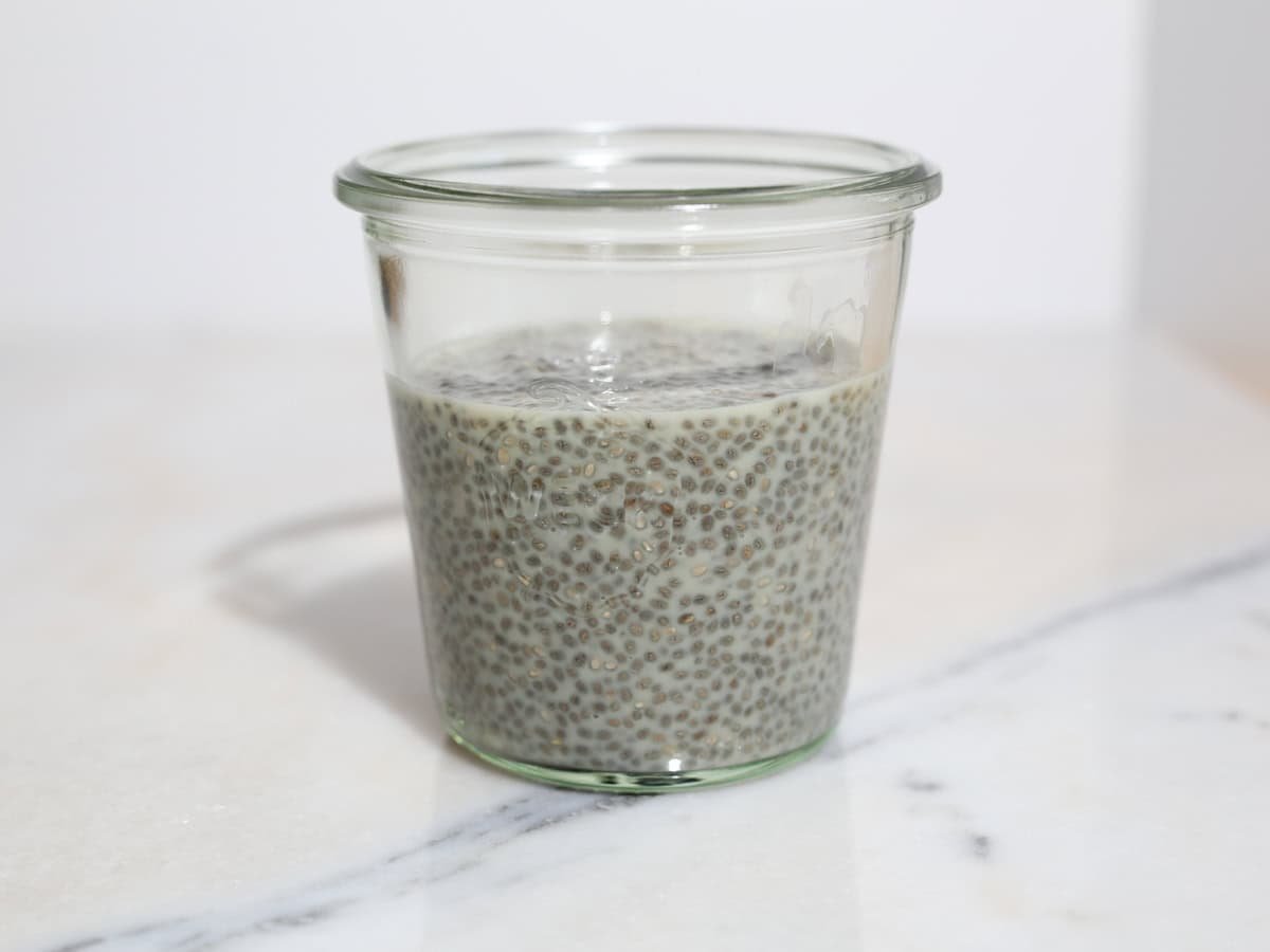 Glass jar of chia seeds and non dairy milk.
