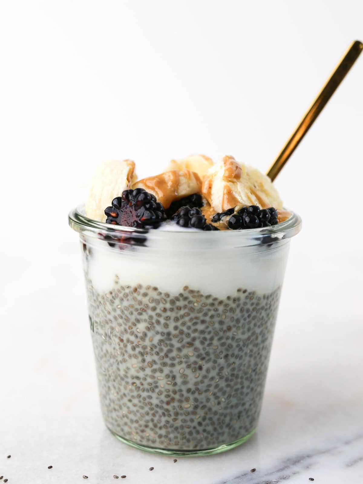 Close up image of this chia pudding in a glass jar with toppings.