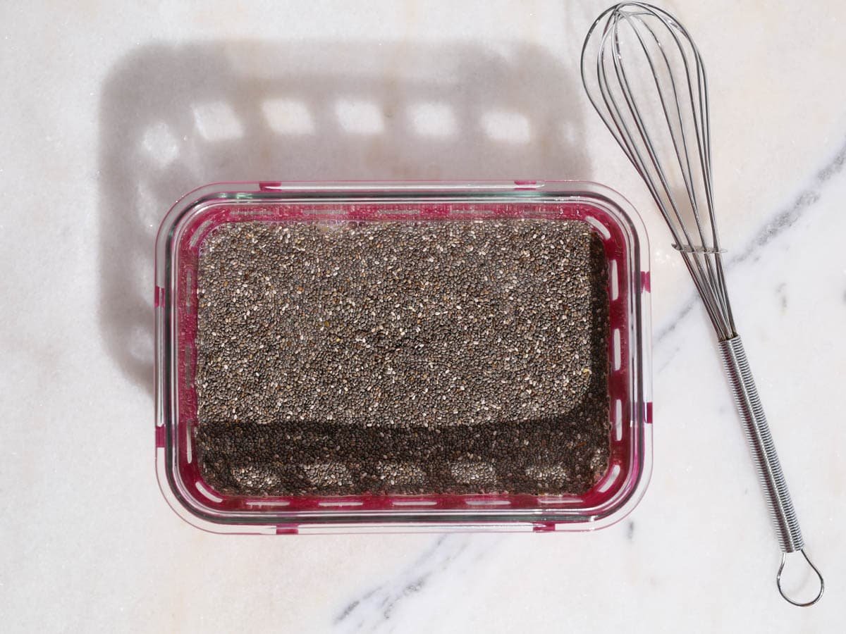 Chia pudding in a container sitting and waiting to be whisked again.