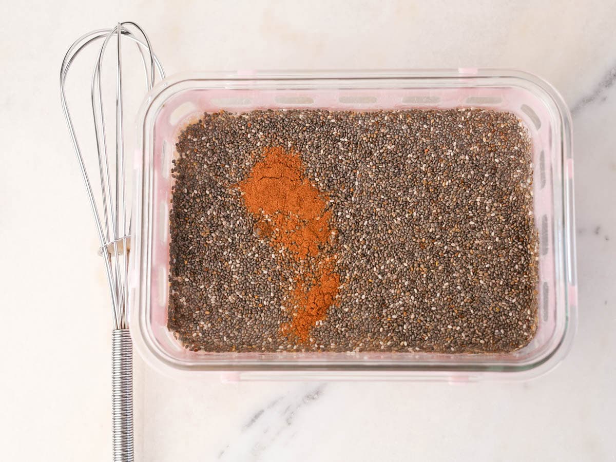 Chia seeds, milk, maple syrup and cinnamon added to container.