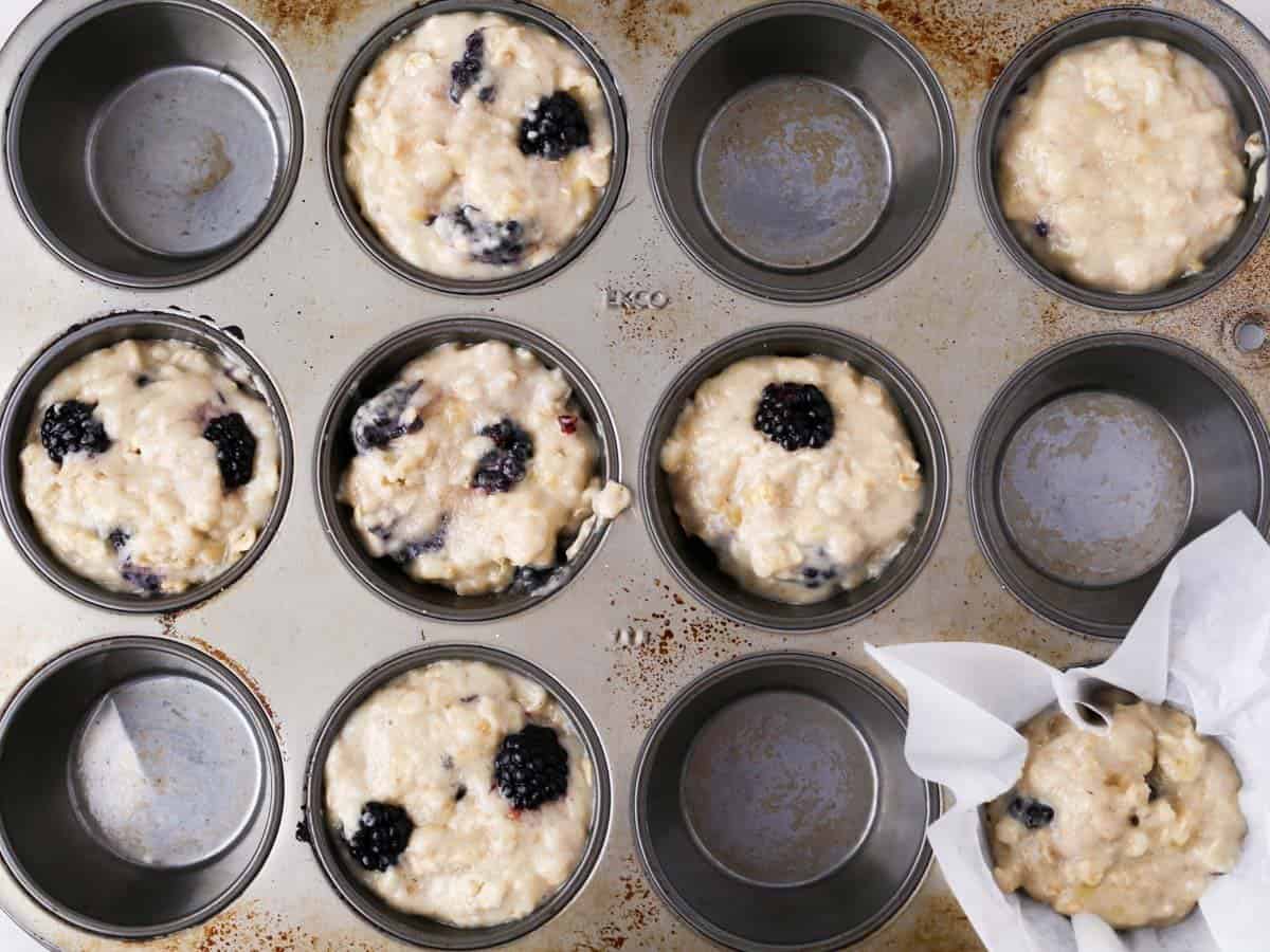 Muffin tin with the batter being added.