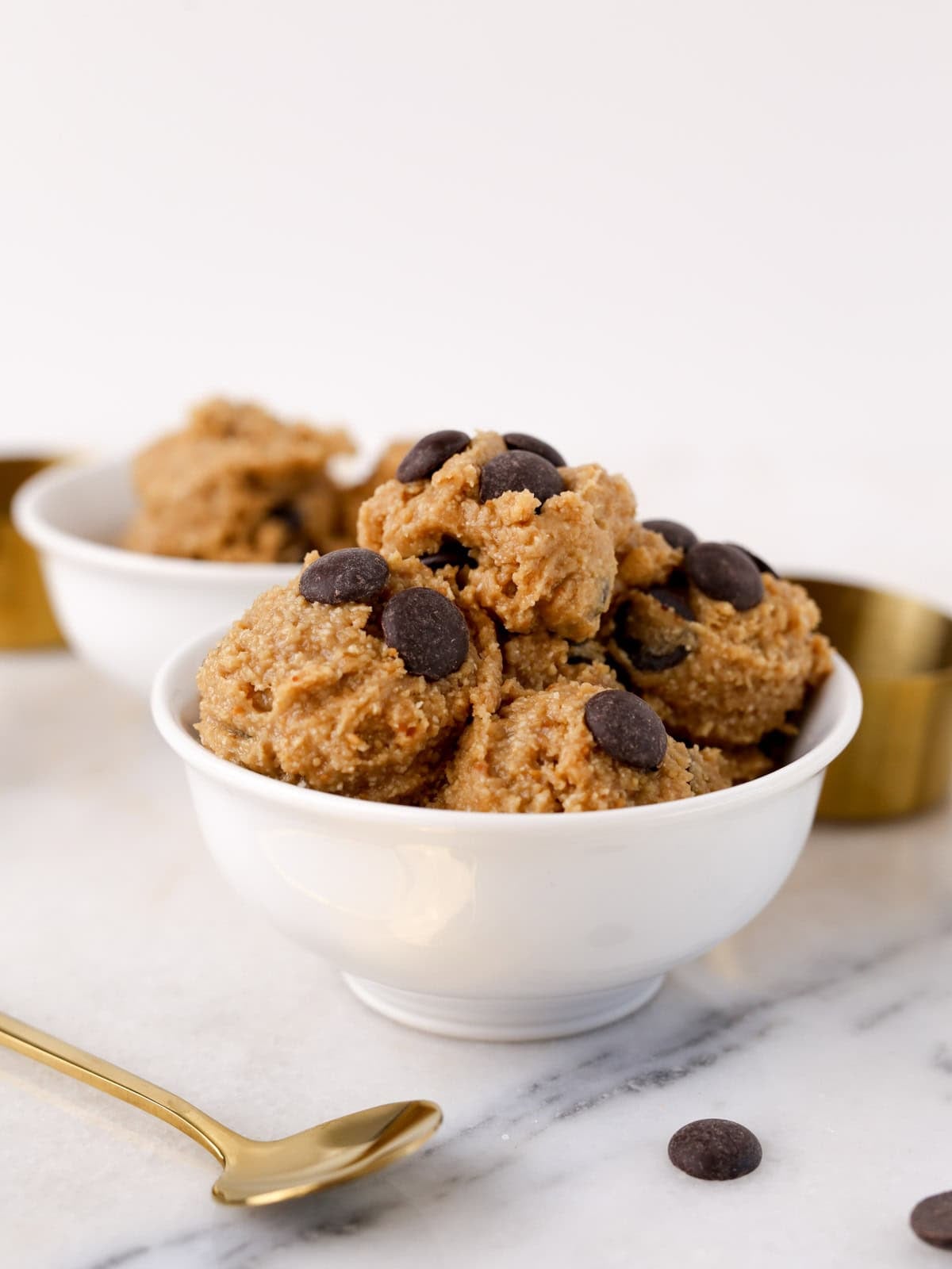 Small white bowl with healthy cookie dough scooped out into it.