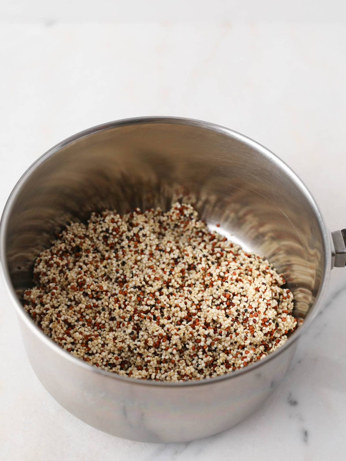 Rinsed quinoa in a pot.
