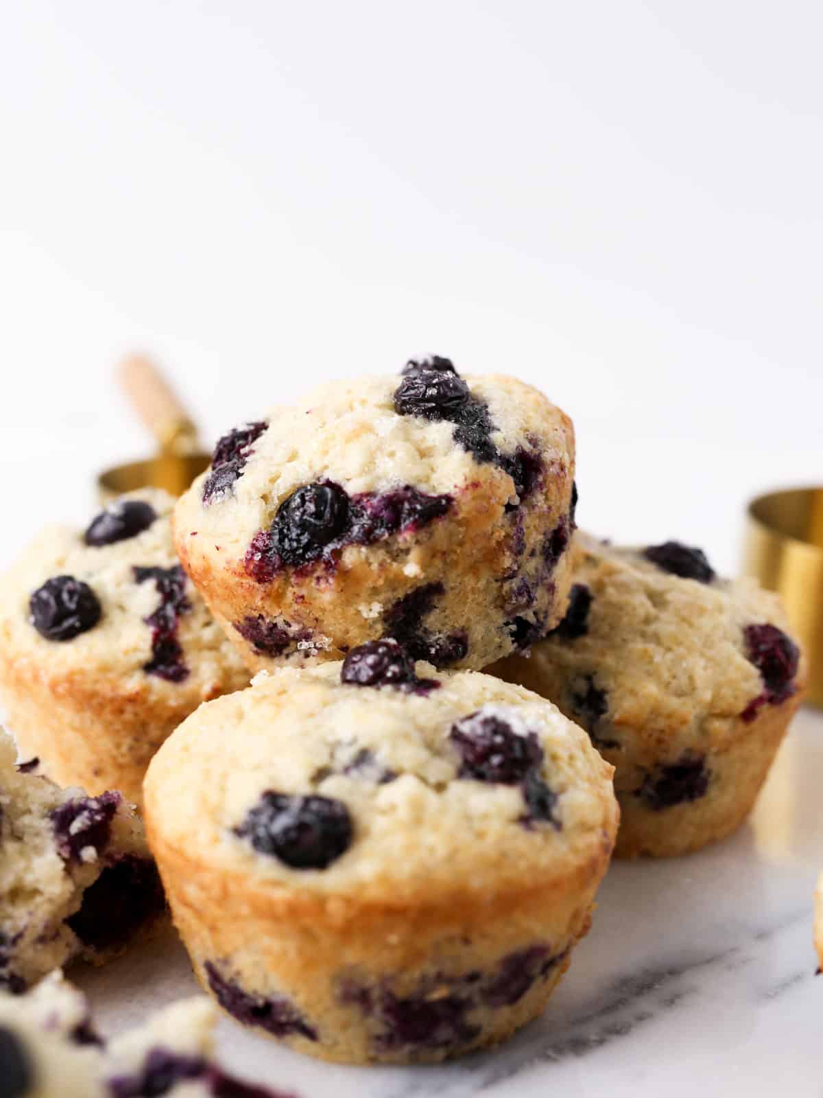 Side view of blueberry muffins vegan stacked on top each other.