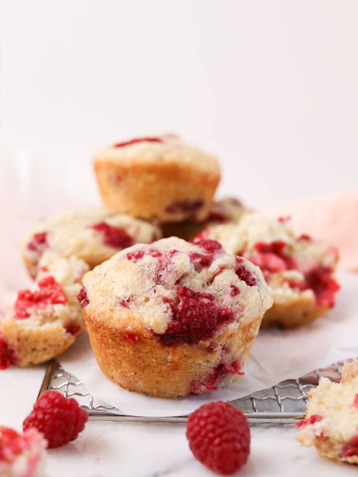 Vegan raspberry muffins stacked on top each other close up image.