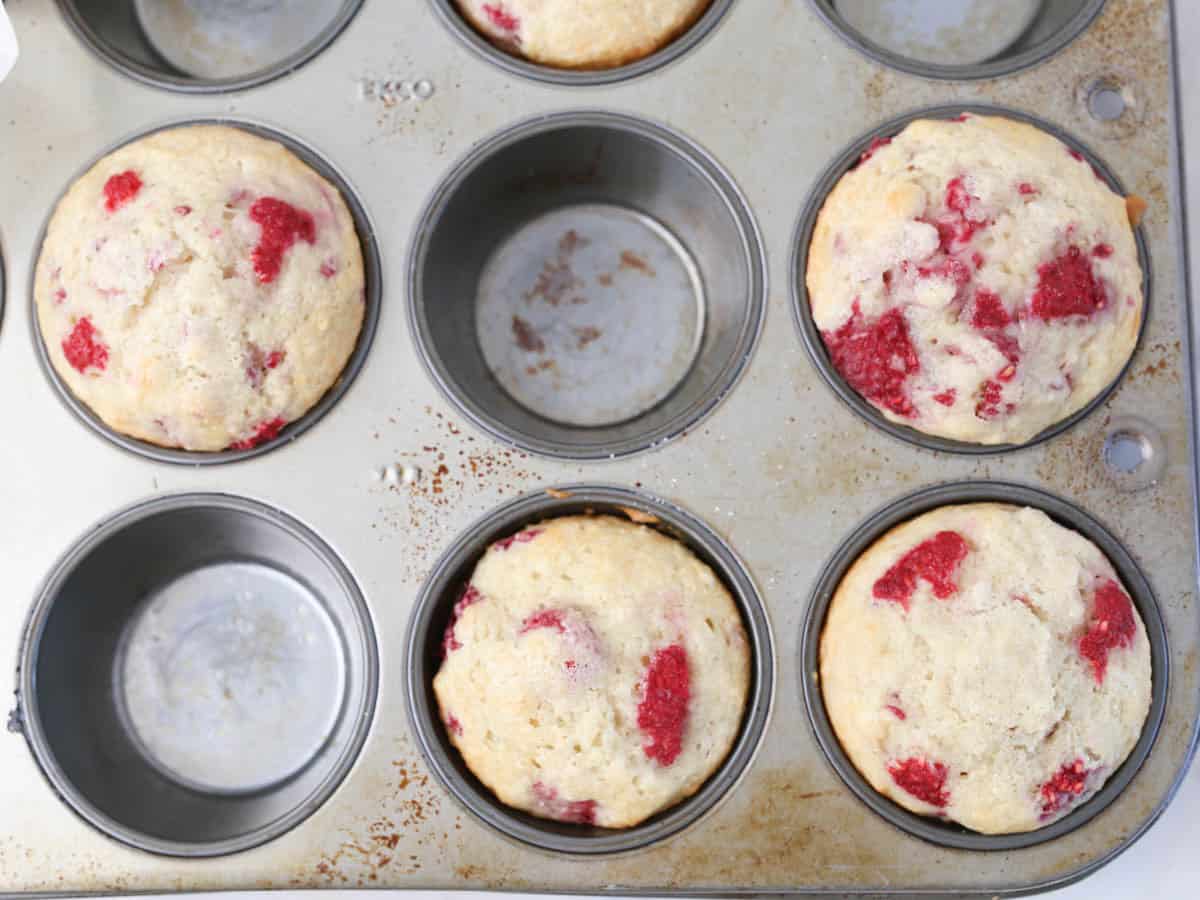 Muffin tin with freshly baked vegan raspberry muffins.
