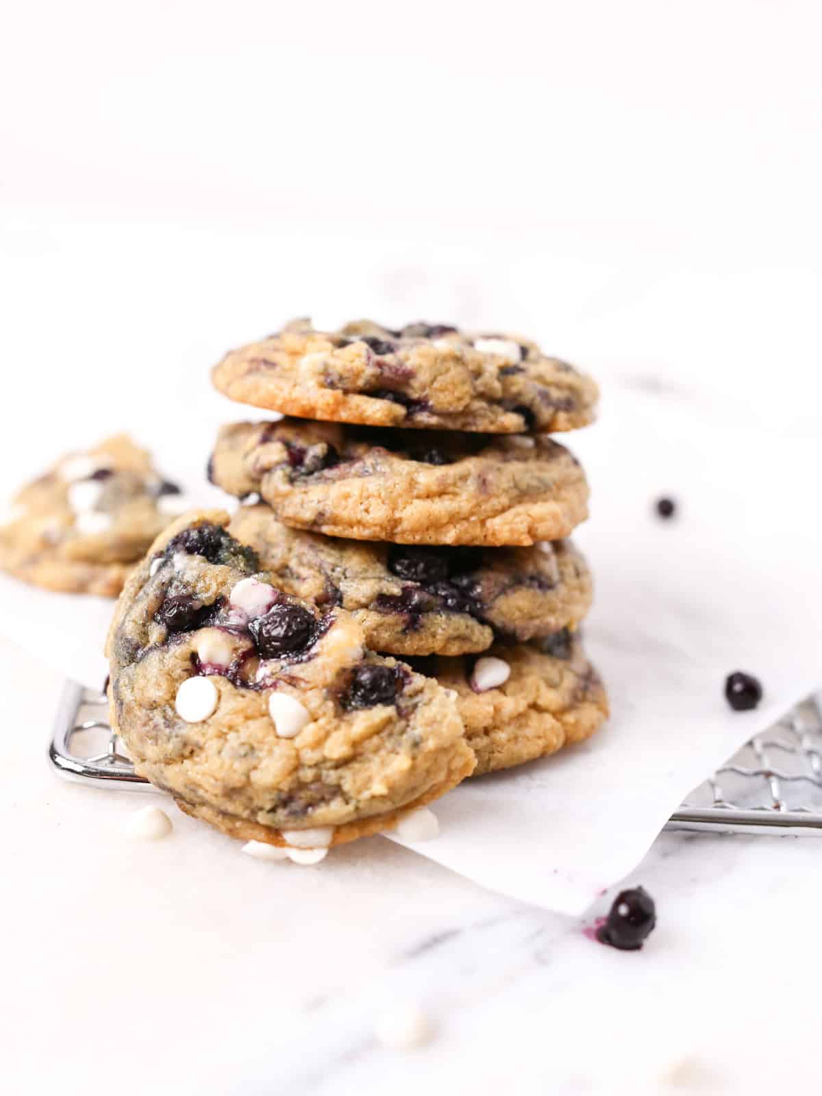 Blueberry white chocolate cookies stacked on top each other tall.