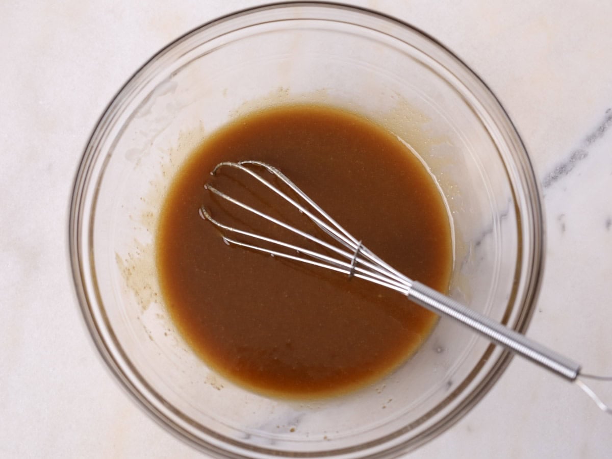 Glass bowl of wet ingredients whisked up.