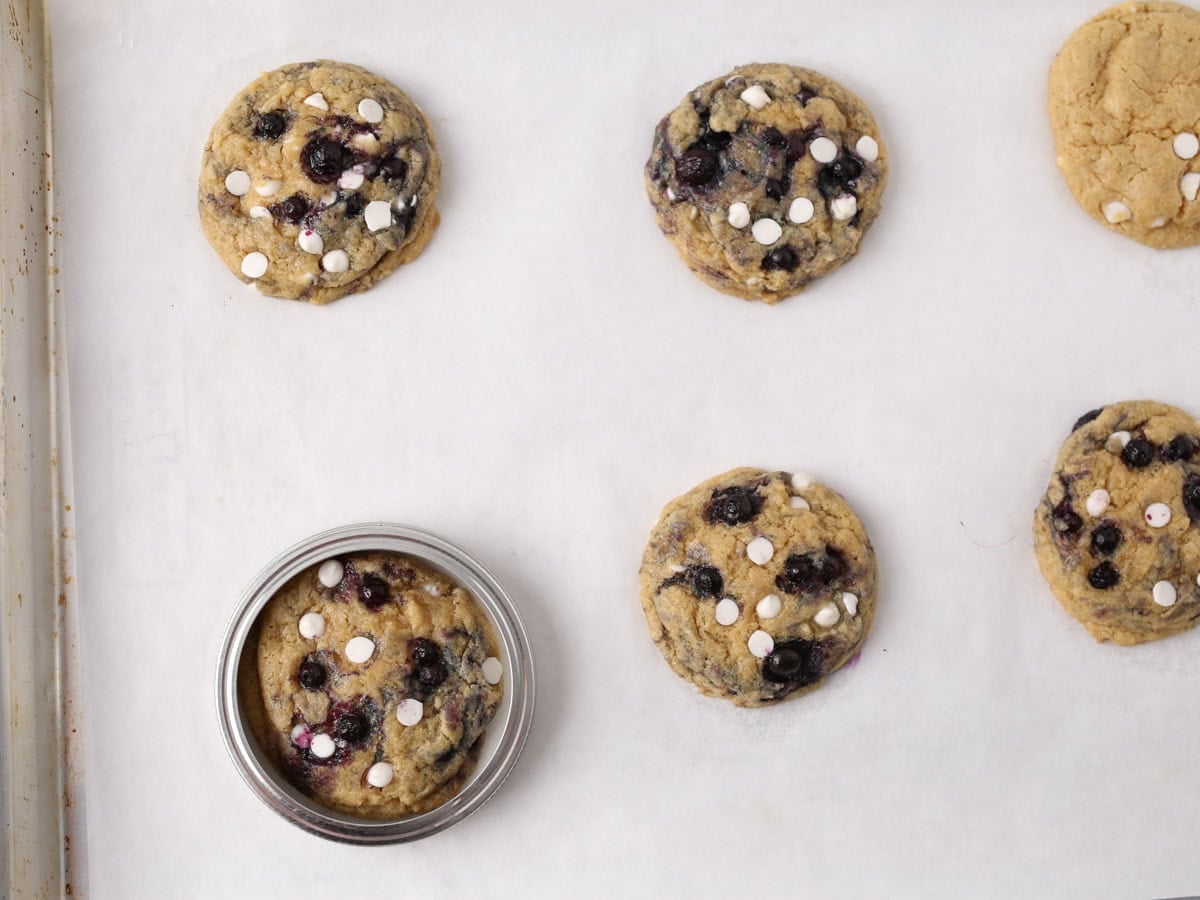 Baking sheet with freshly baked blueberry and white chocolate cookies.