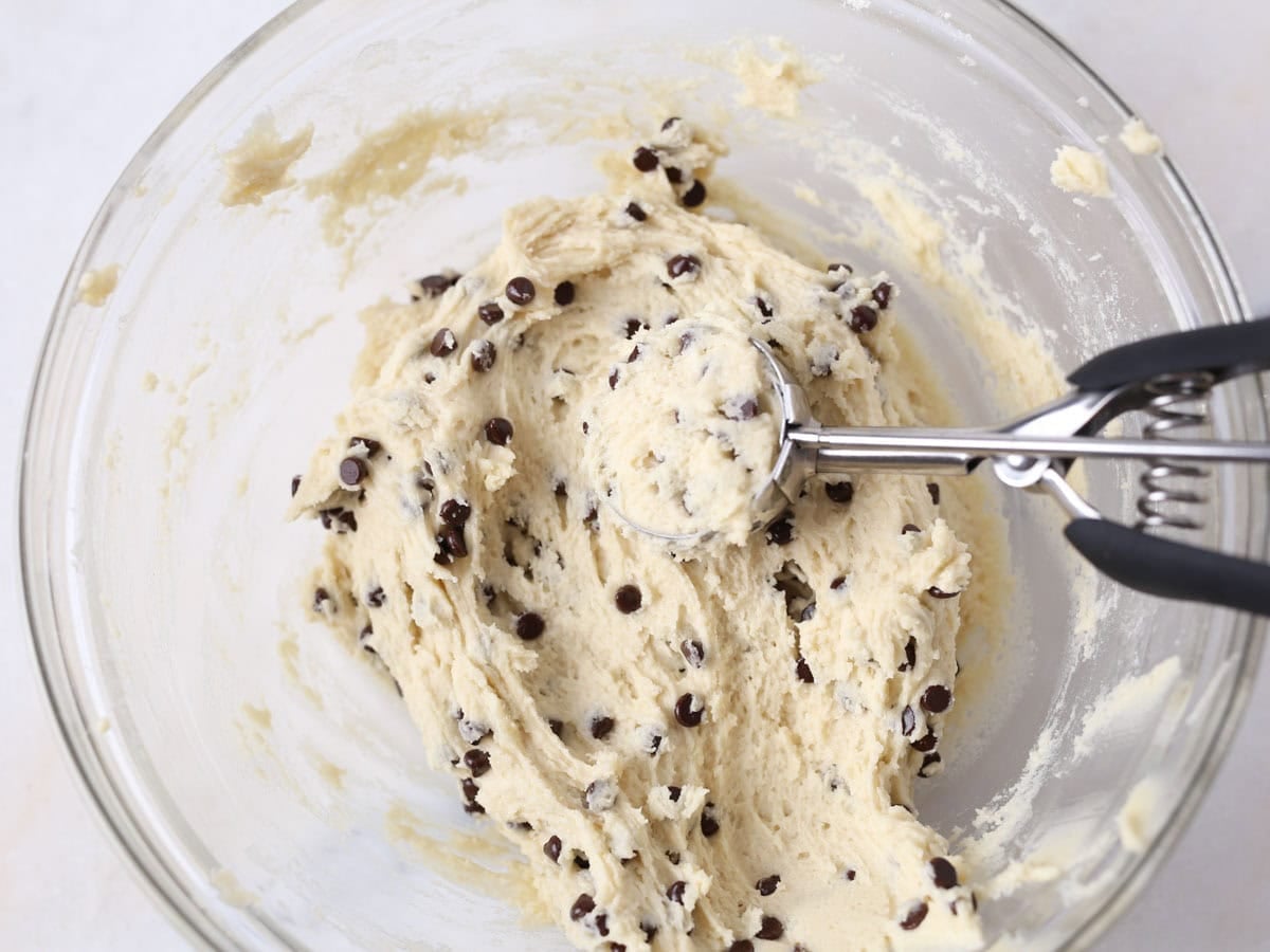 Scooping cookie dough out into balls.