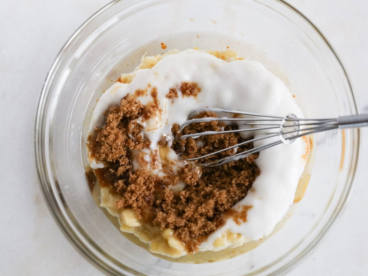 Glass bowl with wet ingredients to make this chocolate chunk banana bread.