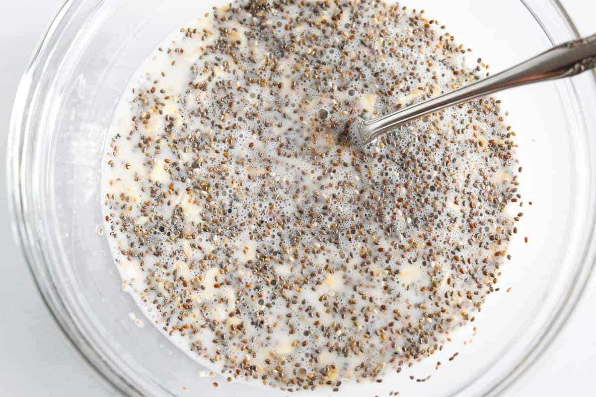 Overnight oats and chia all mixed up in glass bowl.