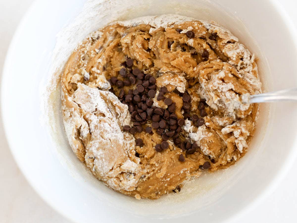 Chocolate chips being folded into this vegan chocolate chip cookie dough.