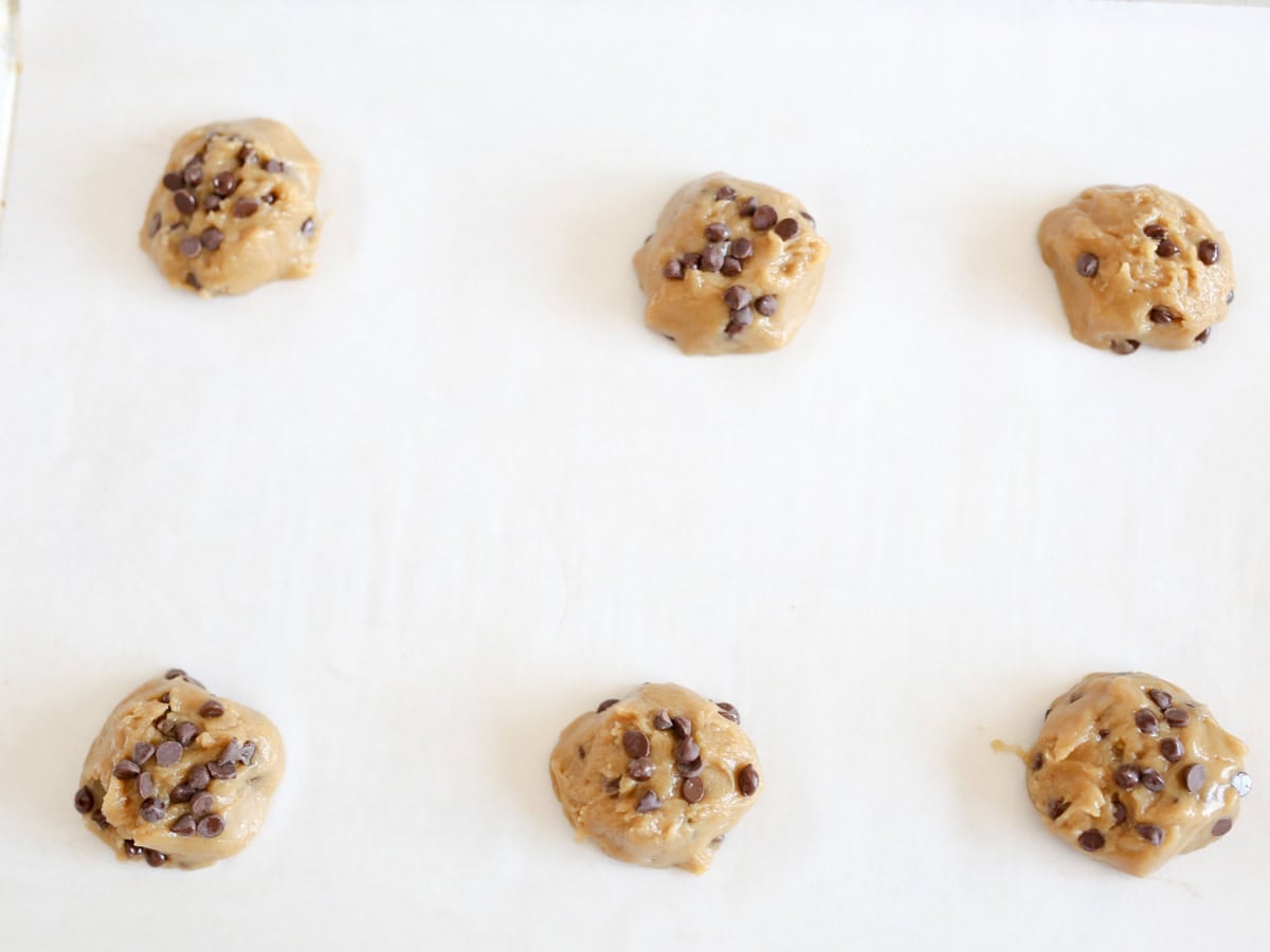 Cookie dough ball on baking sheet ready to be baked.