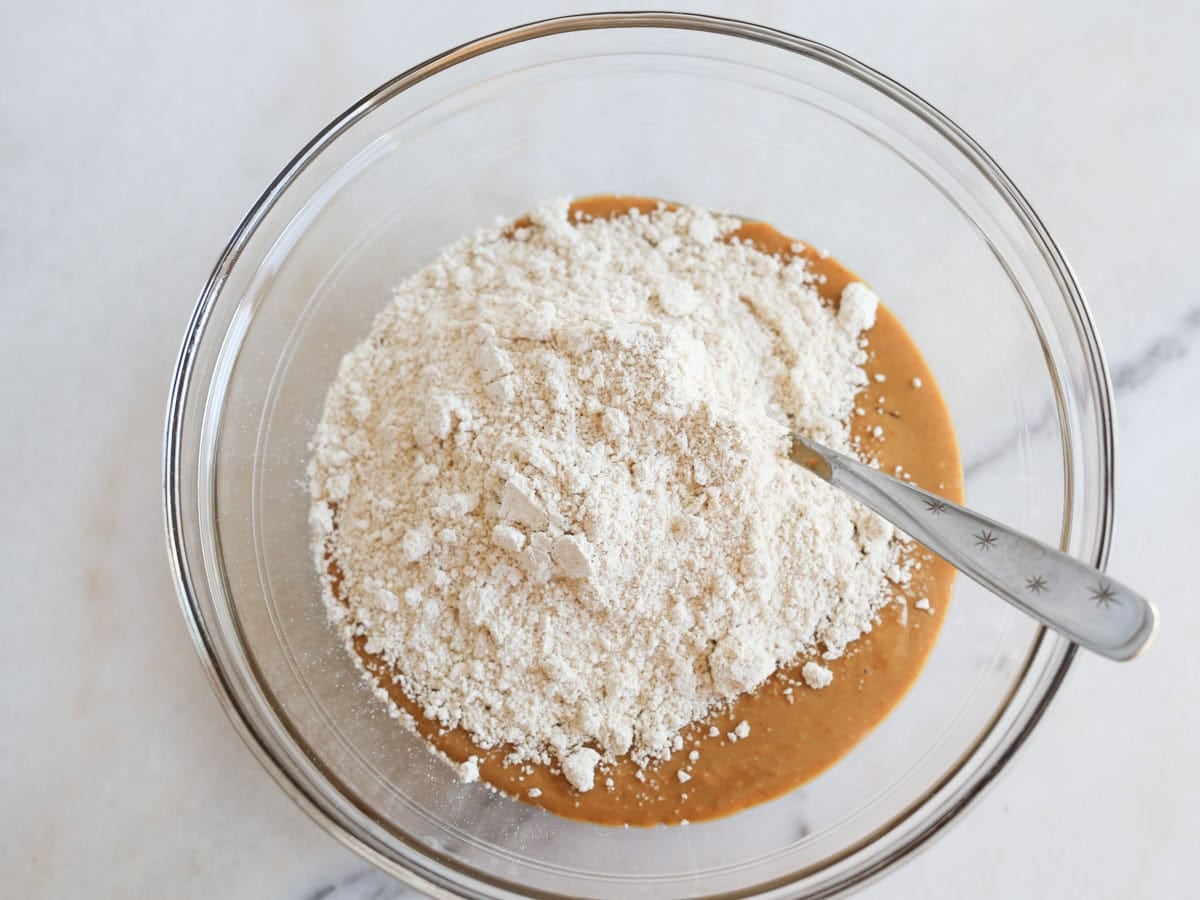 Oat flour and peanut butter mixture in glass bowl.