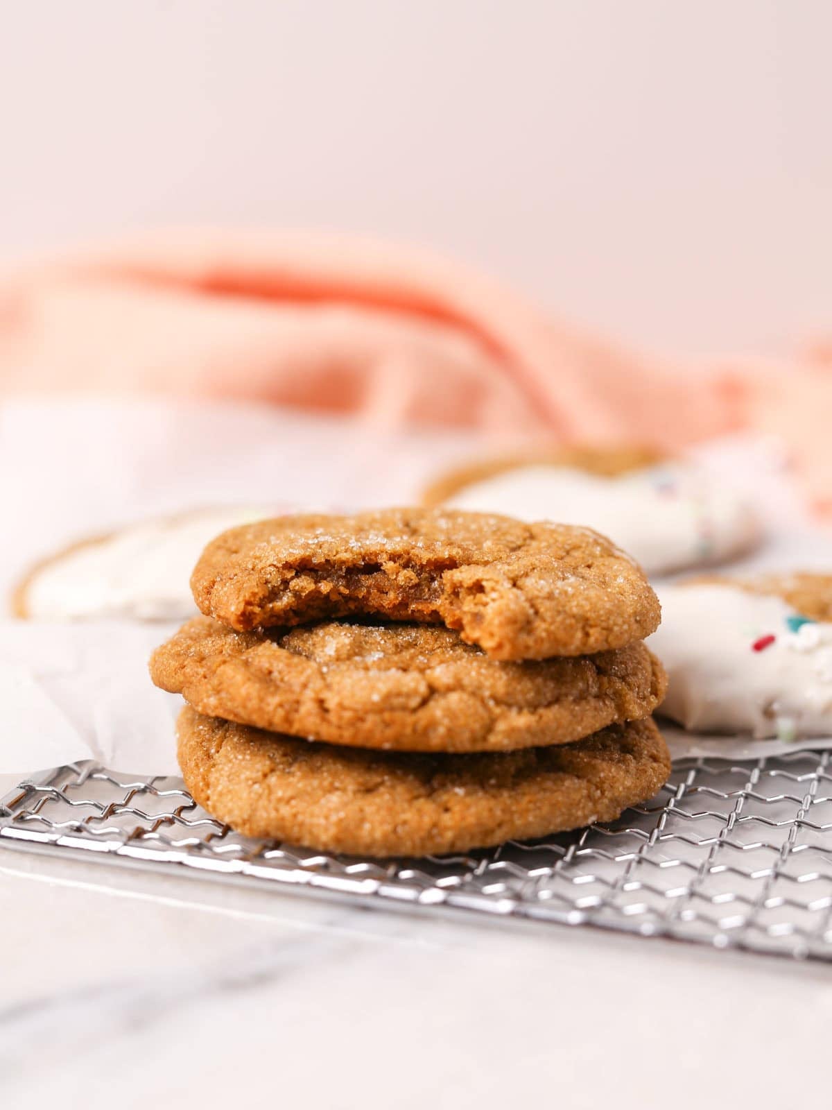 3 stacked vegan ginger cookies with bite taken out of top one.